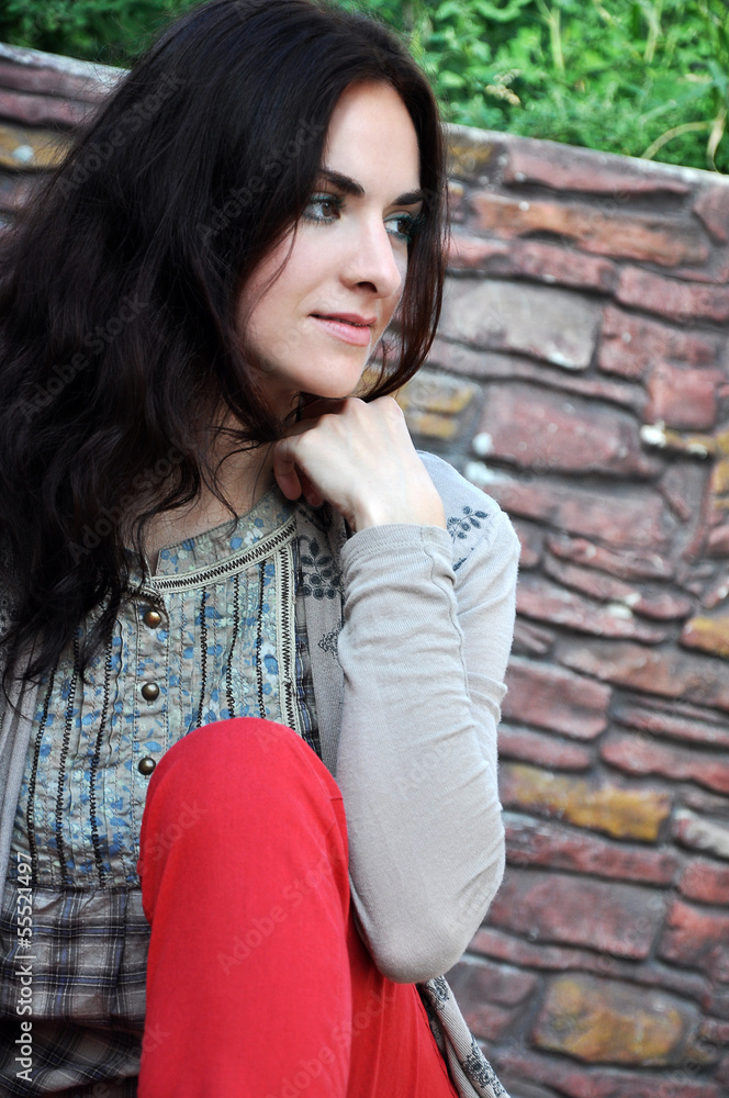 Dark-haired girl sitting on the bench Dark-haired girl sitting on the bench