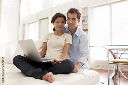 Cheerful Couple Using Laptop Together At Home