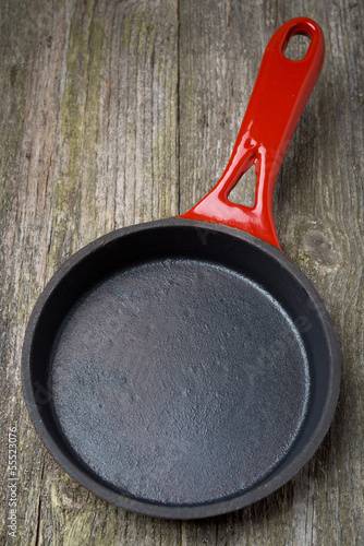 empty frying pan on a wooden background (and space for text)