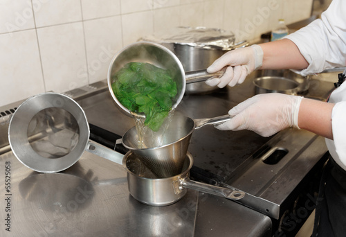 Tableau sur toile Chef is blanching fresh spinach