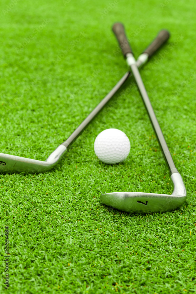 golf ball on tee in front of driver on green course