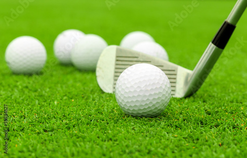 golf ball on tee in front of driver on green course