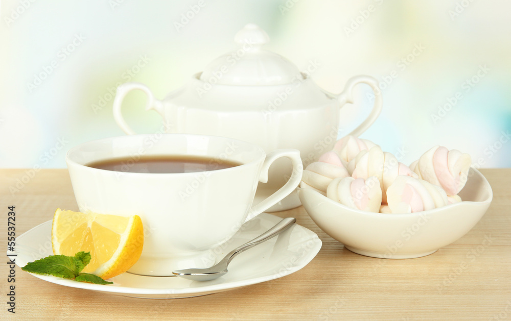Cup of tea with lemon on table on light background Cup of tea with lemon on table on light background