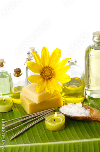 Health spa with massage oil and yellow flower  candle on leaf