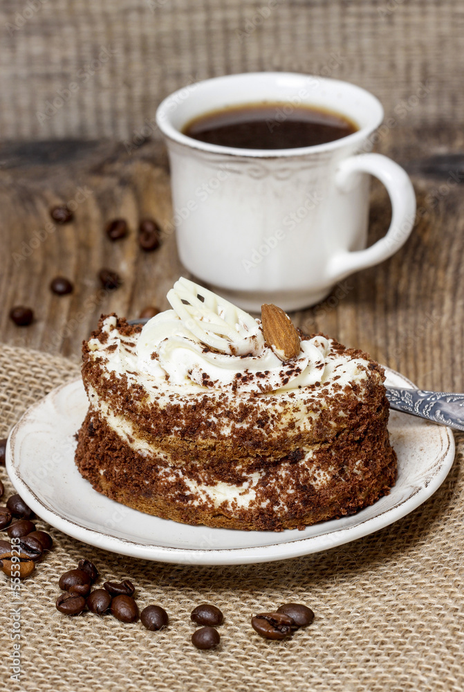 Tiramisu cake on hessian napkin. Coffee beans around. Tiramisu cake on hessian napkin. Coffee beans around.