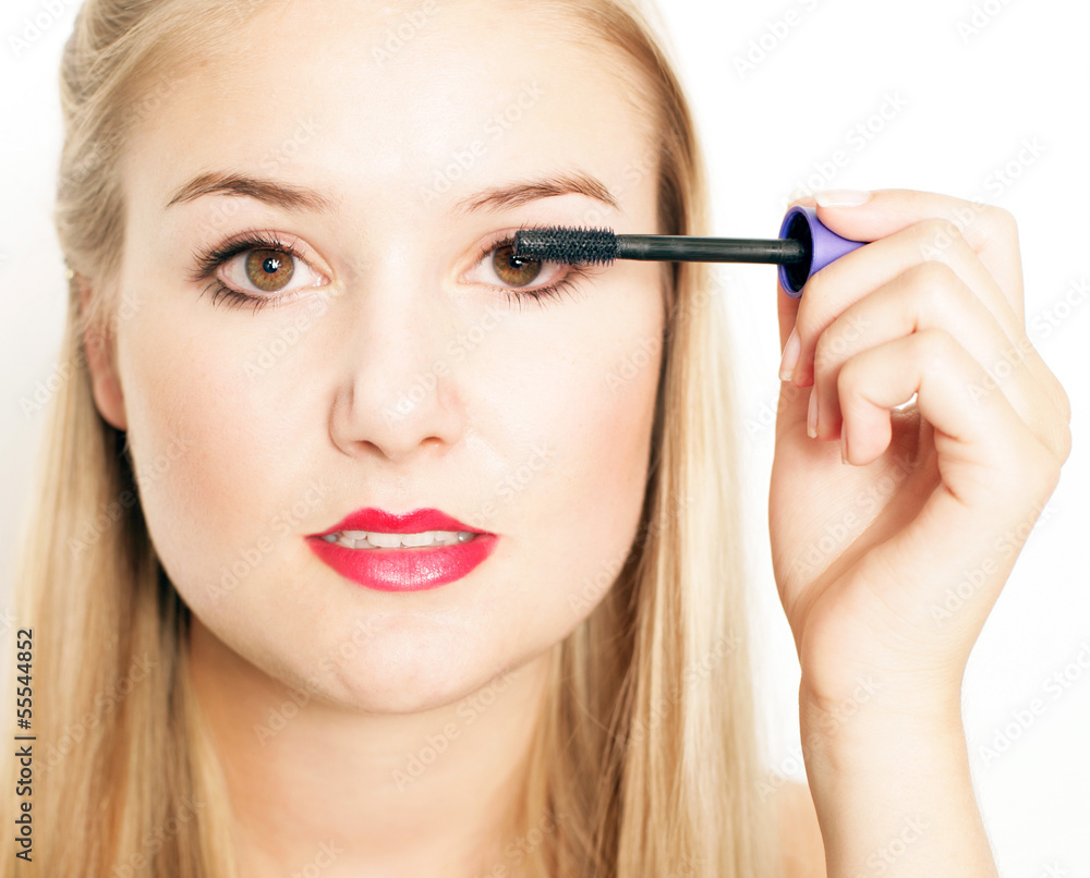 hübsches Mädchen trägt Wimperntusche auf hübsches Mädchen trägt Wimperntusche auf