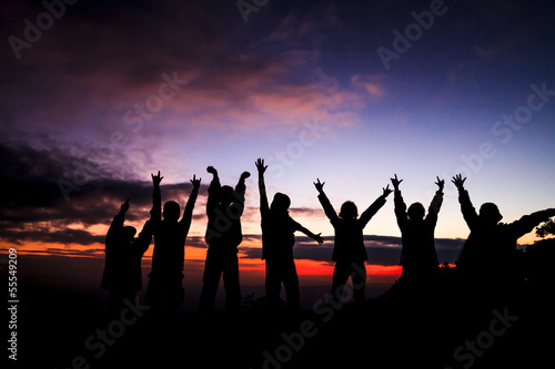 silhouette of group of friends standing in sunset