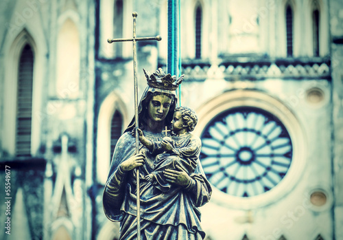 Marble statue of the virgin Mary carrying a child with a diffuse