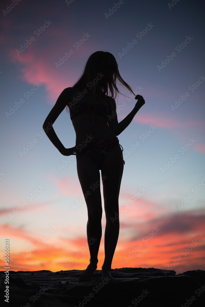 Silhouette of attractive woman posing on the beach