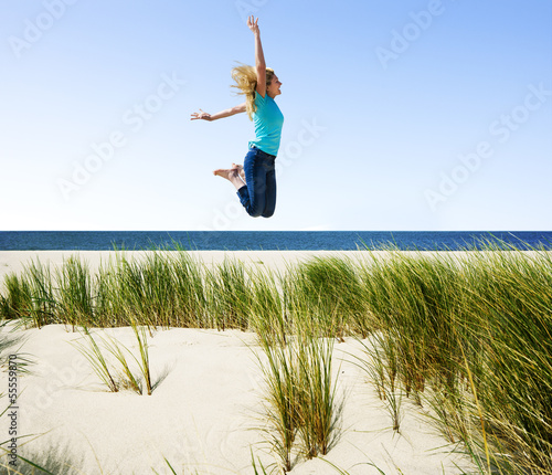 Frau hüpft am Strand