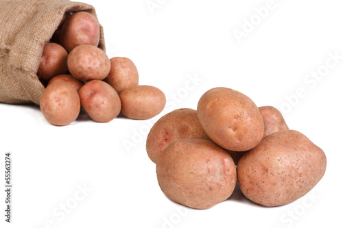 Potatoes in a bag and a pile isolated on white background