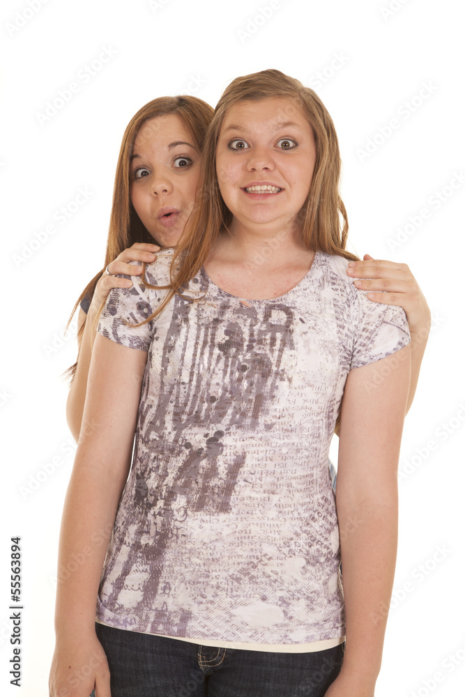 one girl peeking around another one girl peeking around another