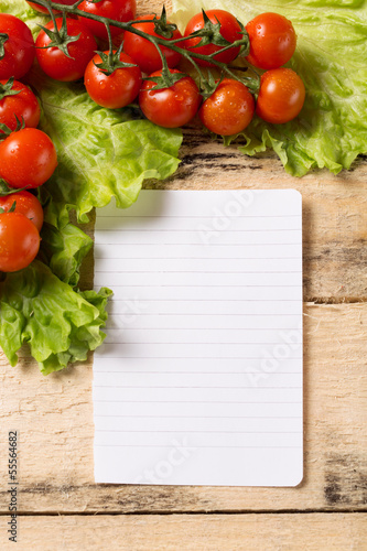 vegetables and blank paper on wood background