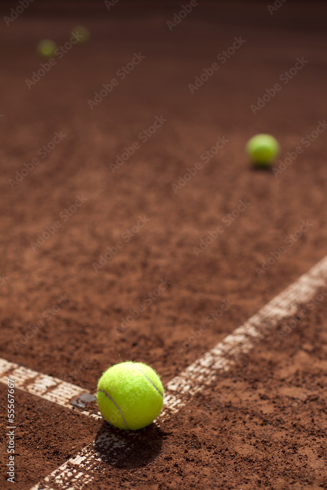 Tennis balls and racket on field