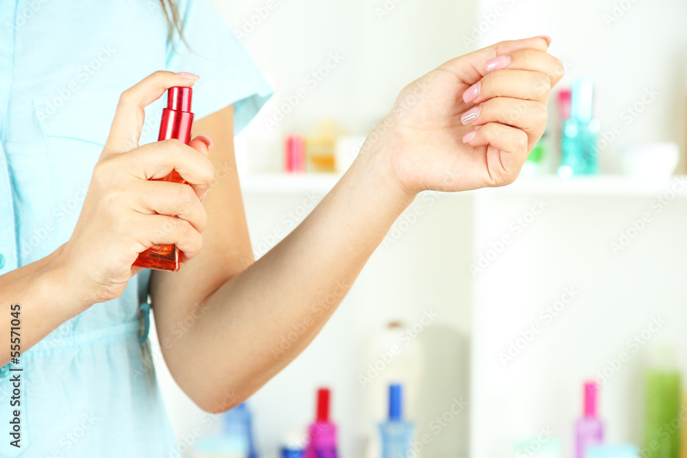 Woman testing perfume on shop windows background Woman testing perfume on shop windows background