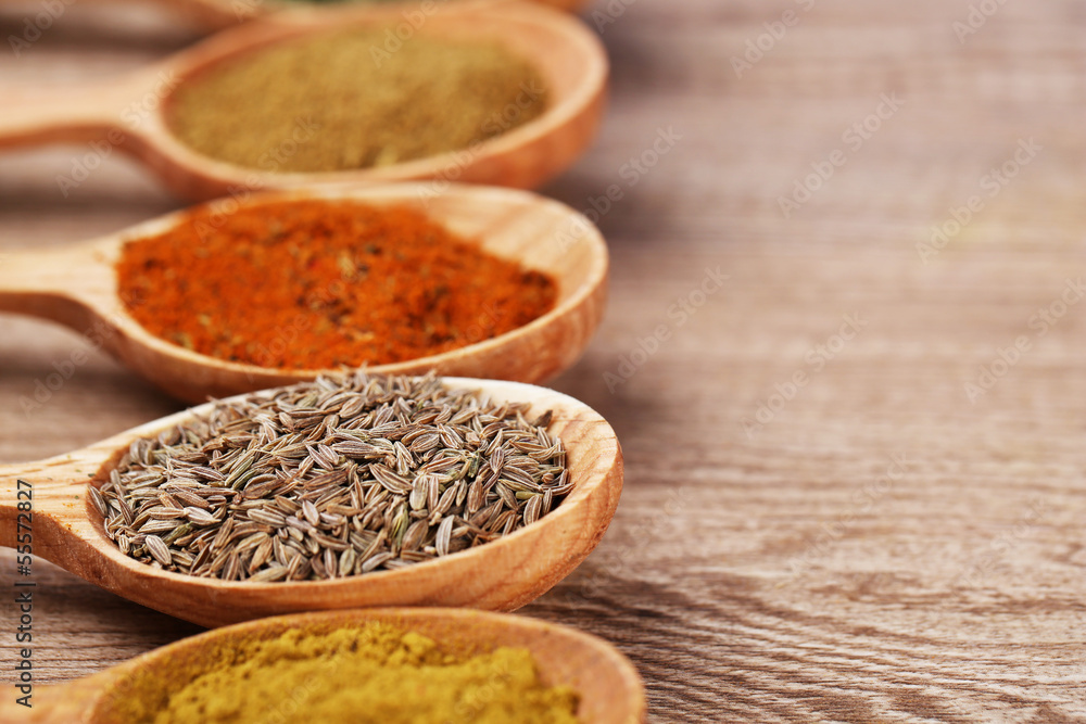 Assortment of spices in wooden spoons on wooden background Assortment of spices in wooden spoons on wooden background