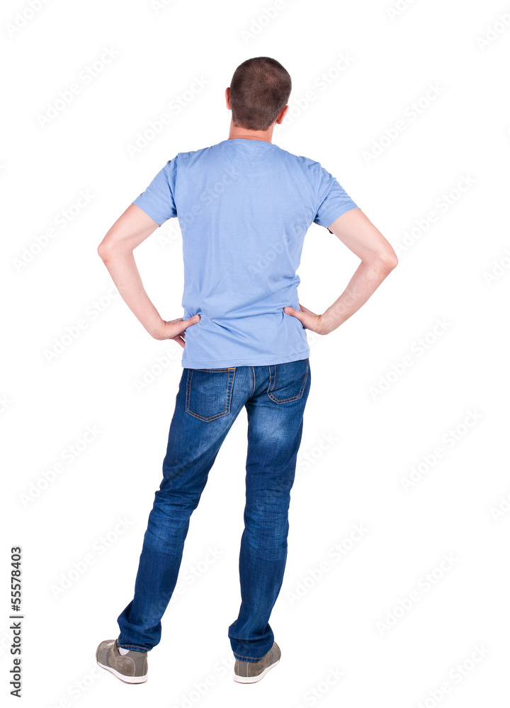 Back view of young man in t-shirt and jeans looking. Back view of young man in t-shirt and jeans looking.