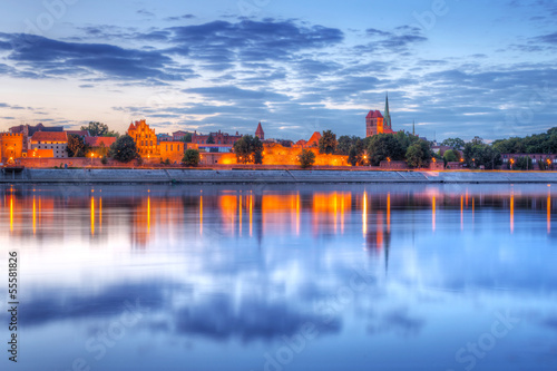 Torun old town reflected in Vistula river at sunset, Poland