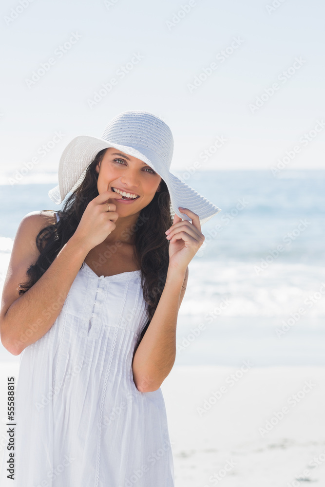 Beautiful brunette in white sunhat looking at camera