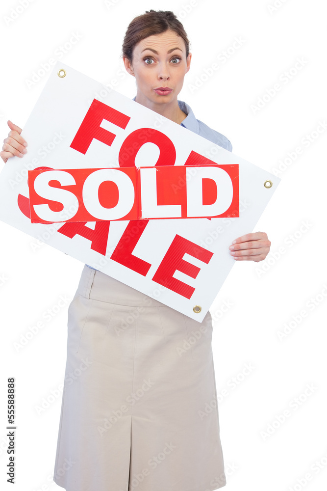 Estate agent showing for sale sign with sold sticker across it Estate agent showing for sale sign with sold sticker across it