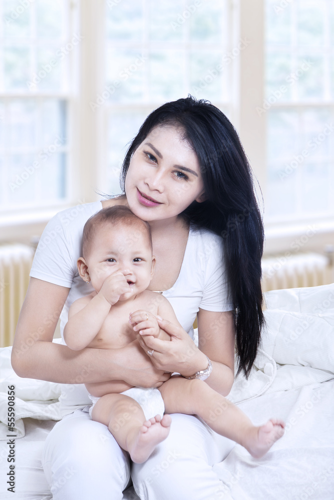 Asian mother and baby sitting in living room Asian mother and baby sitting in living room