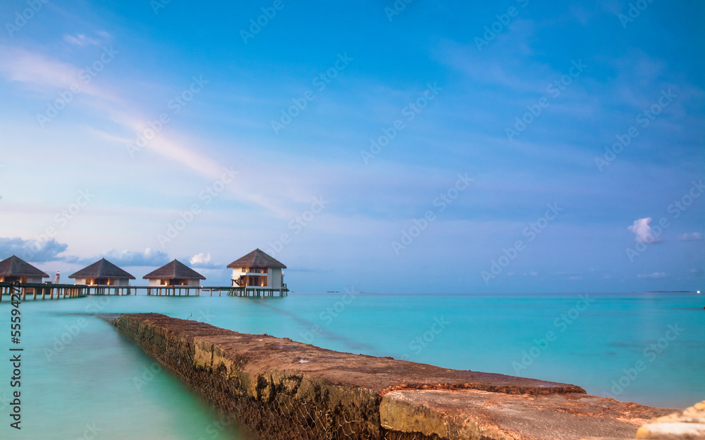 Fototapeta premium Over water bungalows with steps into amazing green lagoon