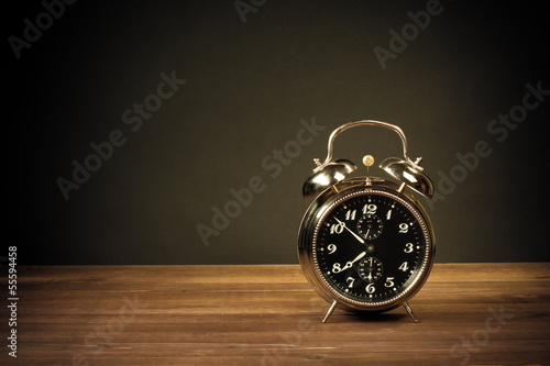 Retro alarm clock on table on dark background