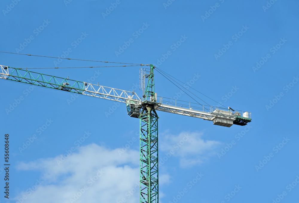 Green construction tower crane against blue sky Green construction tower crane against blue sky