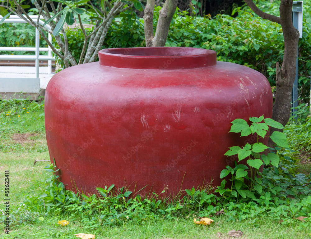The old big cement red jar in garden The old big cement red jar in garden