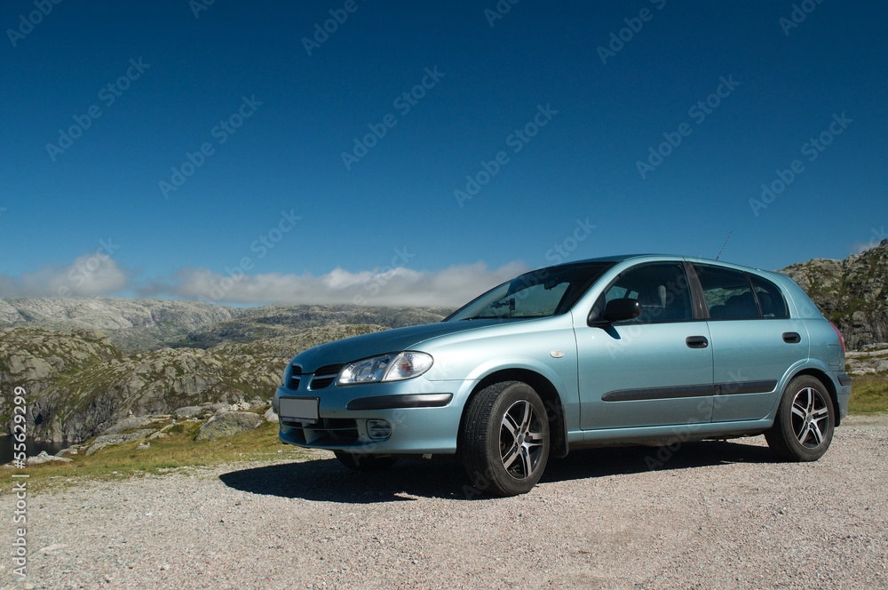 Light blue car in front of the Norwegian mountains