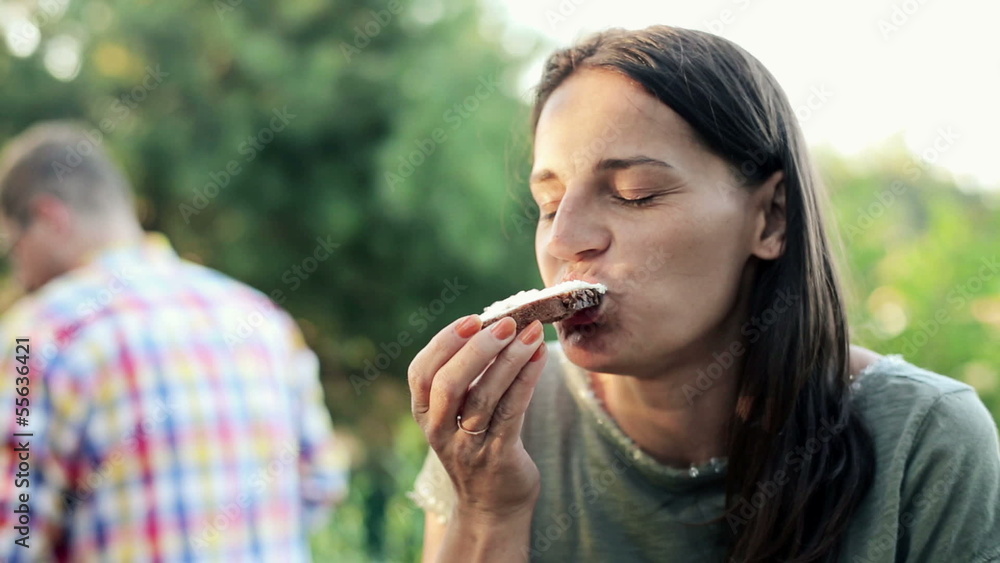 Happy woman eating tasty sandwich in the garden Happy woman eating tasty sandwich in the garden