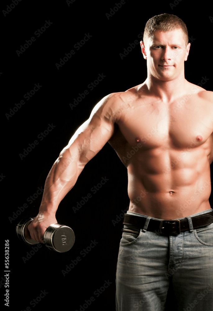 Handsome muscular man working out with dumbbells Handsome muscular man working out with dumbbells