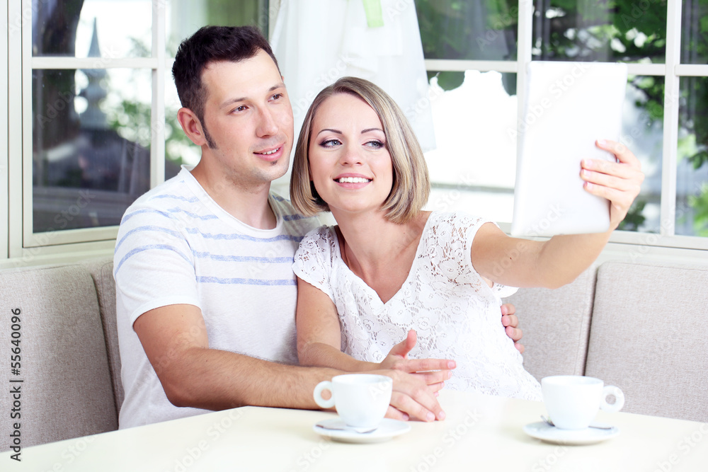 Young couple taking photo with tablet at home Young couple taking photo with tablet at home
