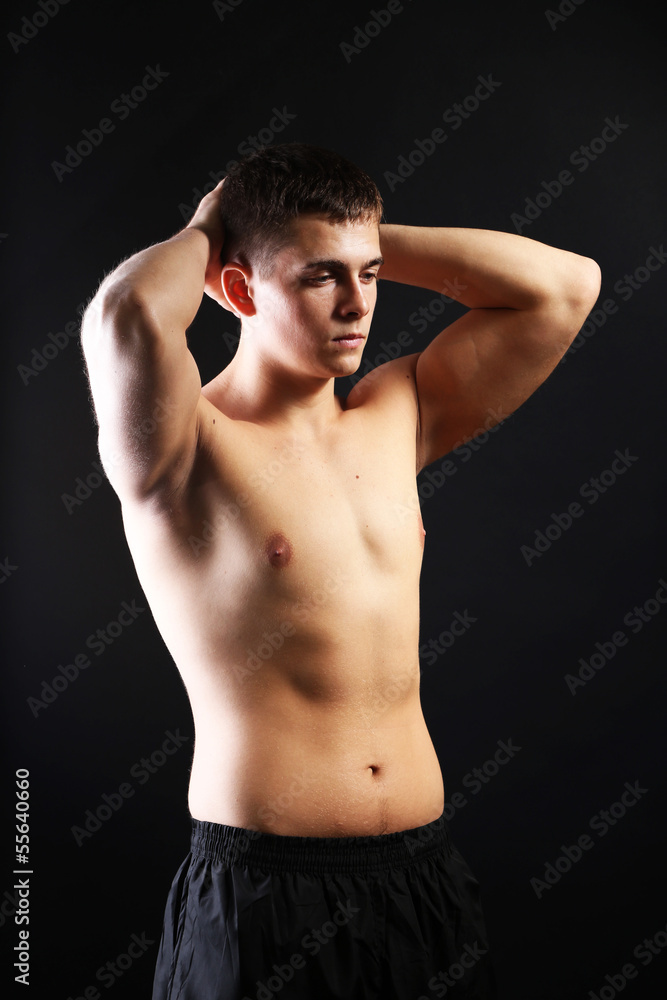 Handsome young muscular sportsman, on dark background Handsome young muscular sportsman, on dark background