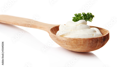 Sour cream in spoon isolated on white