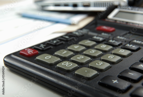 Calculator, pen, folder with documents, laptop