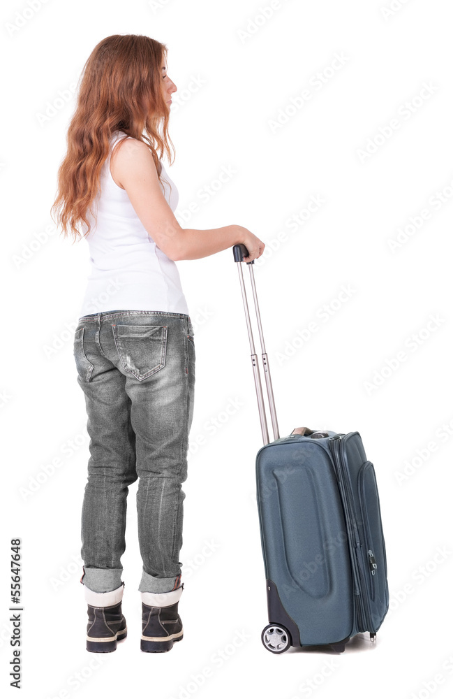 Back view of stylishly dressed woman with suitcase looking up Back view of stylishly dressed woman with suitcase looking up