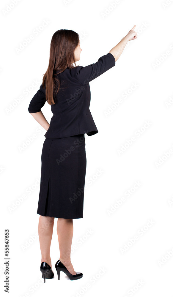 Back view of young brunette business woman pointing at wall. Back view of young brunette business woman pointing at wall.