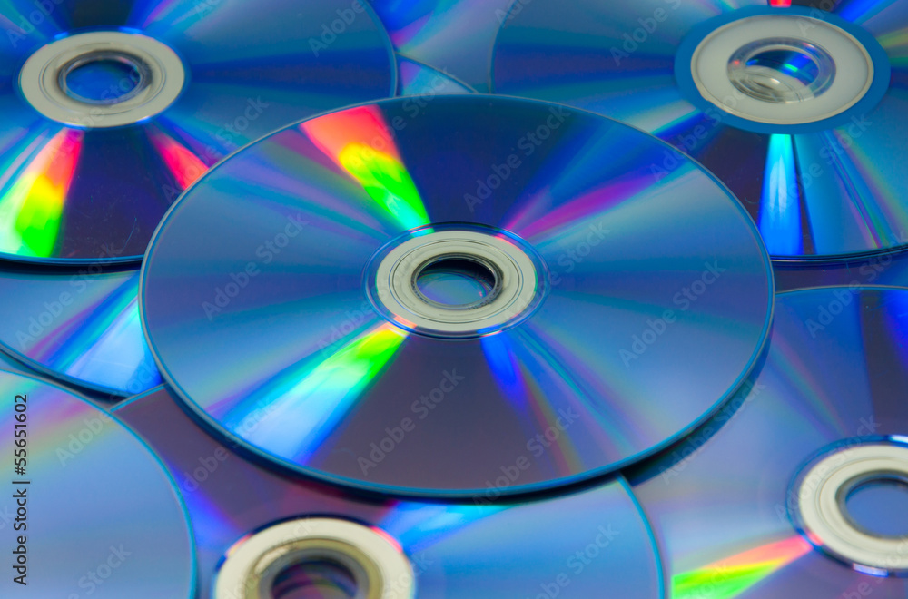 colorful compact discs set of DVD scattered on a table colorful compact discs set of DVD scattered on a table
