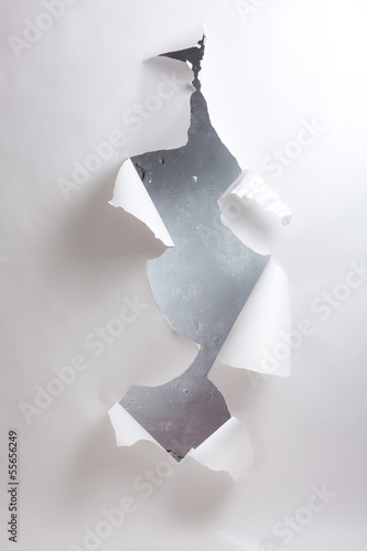 Hole in the paper with torn edges.