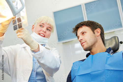 Zahnarzt zeigt Patient Karies auf R  ntgenbild