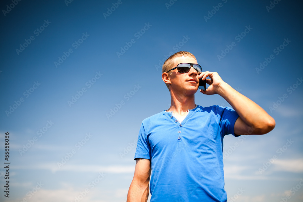 Obraz premium Young man using mobile smart phone, summer outdoor