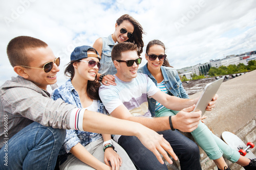 group of teenagers looking at tablet pc