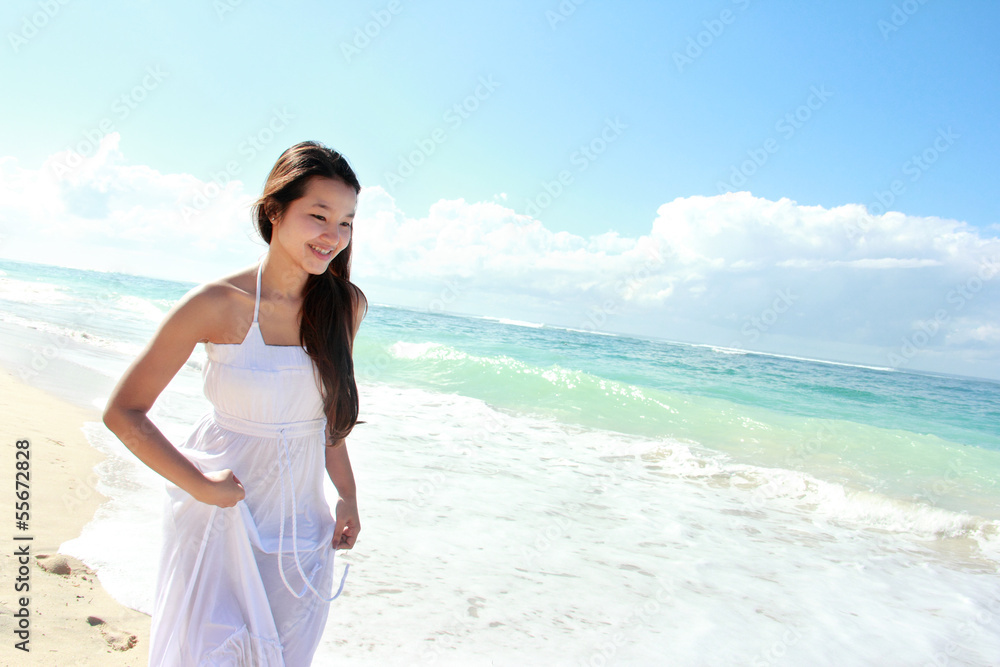 Young happy woman running on the beach Young happy woman running on the beach