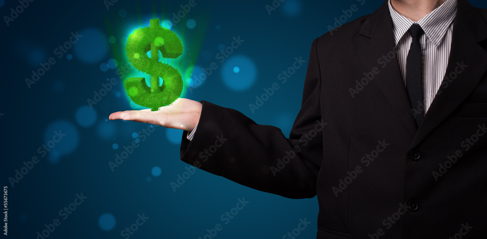 Young businessman presenting green glowing dollar sign Young businessman presenting green glowing dollar sign