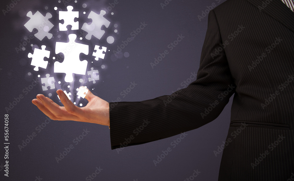 Puzzle pieces in the hand of a businessman Puzzle pieces in the hand of a businessman