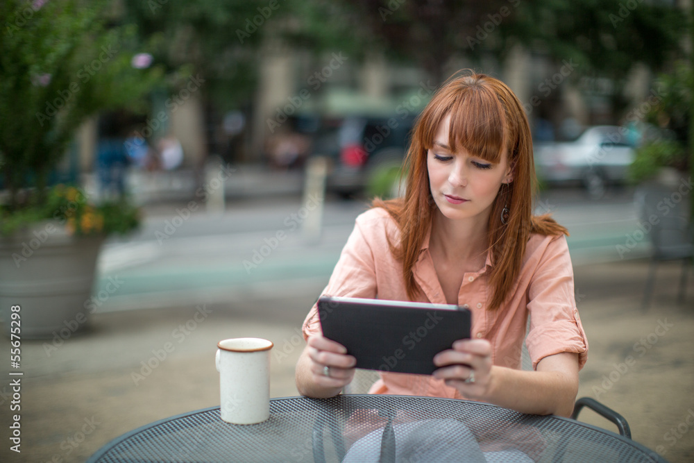 Caucasian woman using ipad tablet computer outdoor Caucasian woman using ipad tablet computer outdoor