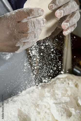 African hands preparing dough for a pizza