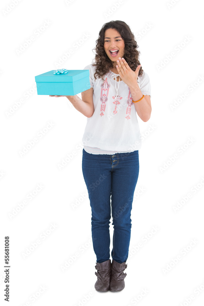 Surprised casual brunette holding a present Surprised casual brunette holding a present