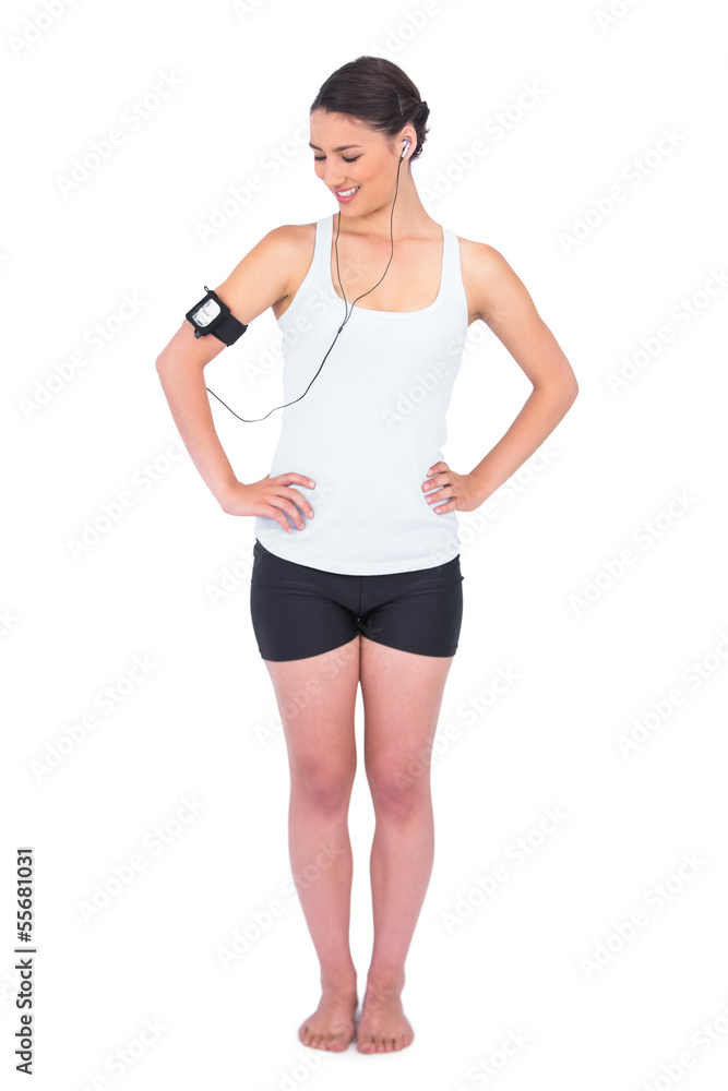 Smiling slender model wearing armband holding mp3 player Smiling slender model wearing armband holding mp3 player